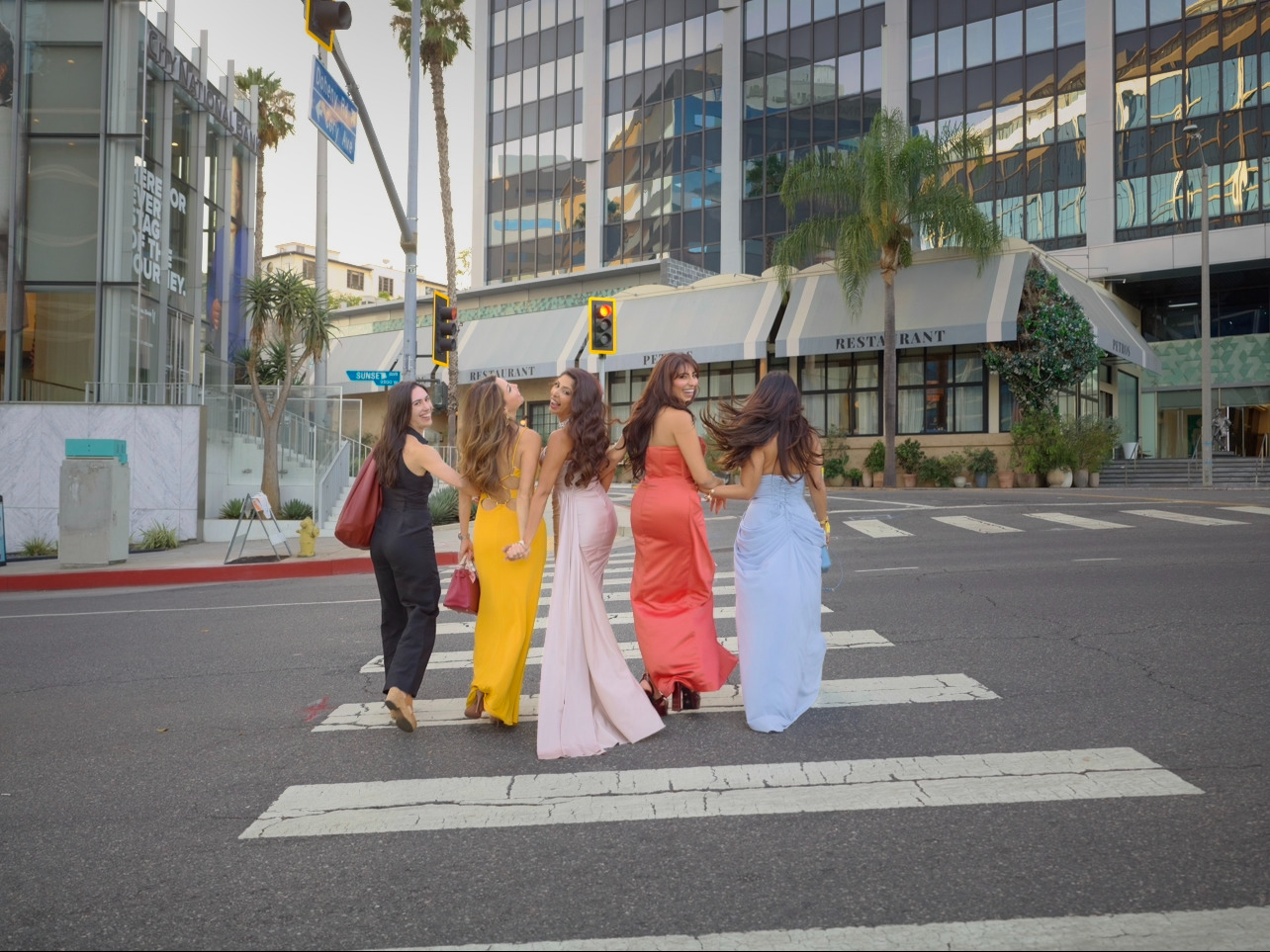 The Kitty Party circle crossing a Beverly Hills street in evening gowns.